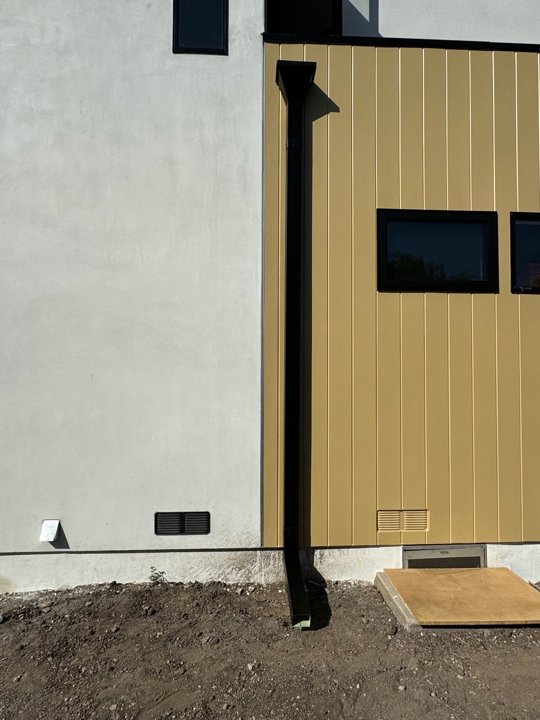 Black box square downspout running down a two-tone modern home in the Los Angeles area